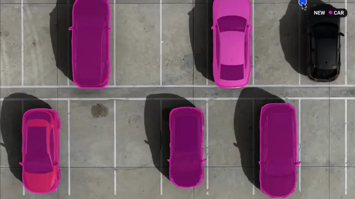 Cars in a parking lot seen from above, each one segmented with the Smart Tool